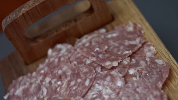 Frische italienische Wurst in Scheiben und Mozzarella-Käse in Herzform auf einem hölzernen Tablett-Tisch, Zubereitung herzförmiger Pizza zum Valentinstag für einen geliebten Menschen. 4K-Video. Ansicht von oben — Stockvideo