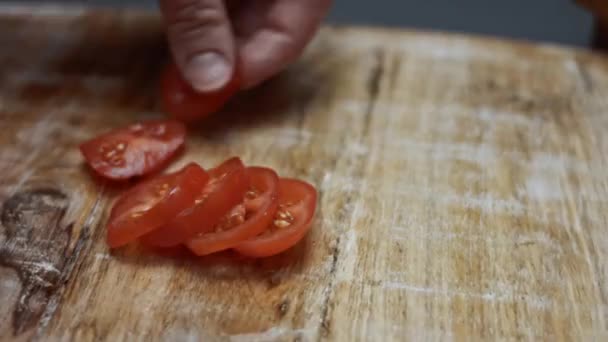 スライスしたチェリートマト、イタリアのサラミソーセージ、モッツァレラチーズは、木製のトレイテーブルの上にピザの材料としてハートの形をしています。愛する人のためのバレンタインデーのためのハート型のピザの準備 — ストック動画