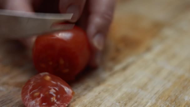 나무 도마 위에 부엌용 칼을 얹은 빨간 체리 토마토를 썰어서 발렌틴 데이에 먹을 피자를 만들었다. 4K 비디오 — 비디오