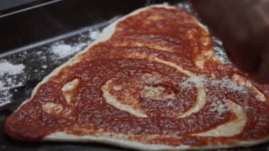 Pişirme tepsisine kalp şeklindeki hamurun üzerine parmesanlı peynir dökmek. Sevgililer Günü için kalp şeklinde pizza hazırlıyorum. Sevdiğim biri için. 4K video