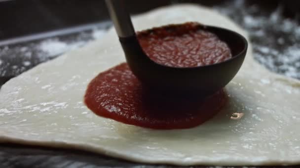 将番茄酱倒在烤盘上,洒在心形面团上.为爱的人准备情人节的心形披萨。4K视频 — 图库视频影像
