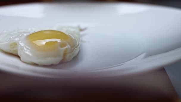 Smażone jajko kurze, kształt serca. Przyprawiam smażone jajko solą. Jedzenie na Walentynki. Pojęcie zabawnej niespodzianki dla ukochanej osoby na specjalną ocasion. Wideo 4K — Wideo stockowe
