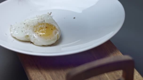 Жареное куриное яйцо, в форме сердца. Добавляю пармиджано Реджано. Еда на День Святого Валентина. Концепция забавного сюрприза для любимого человека для особого случая. 4K видео — стоковое видео
