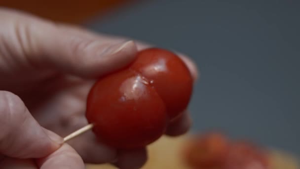 Unindo duas metades de tomate cereja com um espeto de madeira e colocando-o em um prato com ovo frito para o café da manhã. Vídeo 4K. Tiro artístico — Vídeo de Stock