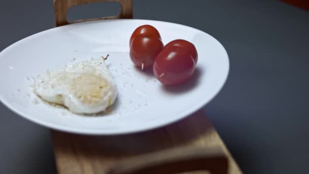 Smażone jajko kurze, kształt serca z serem parmigiano reggiano i pomidorami wiśniowymi. Jedzenie na Walentynki. Pojęcie zabawnej niespodzianki dla ukochanej osoby na specjalną ocasion. 4K — Wideo stockowe