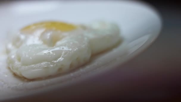 Smażone jaja kurze, kształt w postaci serca. Przyprawy do smażonego jajka z czarnym pieprzem. Jedzenie na Walentynki. Pojęcie zabawnej niespodzianki dla ukochanej osoby na specjalną ocasion. Wideo 4K — Wideo stockowe