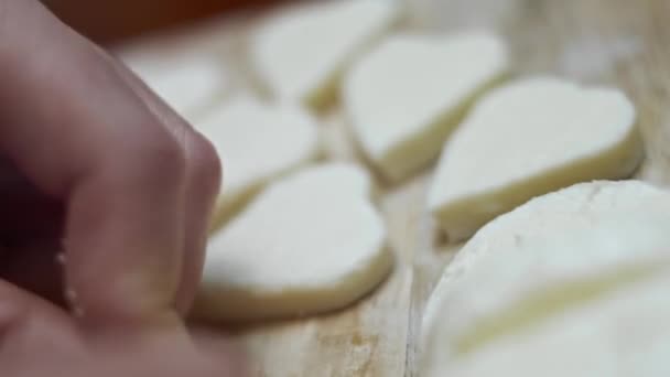 Kobiece dłonie tnące kształty serów mozzarelli na drewnianej desce do krojenia. Przygotowuję jedzenie na Walentynki. Nagranie 4k. Zdjęcia artystyczne — Wideo stockowe