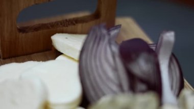 Ahşap tepside ton balıklı pizza için malzemeler - kırmızı soğan, ton balığı parçaları, dansih mavisi peynir ve mozzarella. Sevgililer Günü için kalp şeklinde ton balıklı pizza hazırlıyorum. Sevilen birine sürpriz yemek olarak.