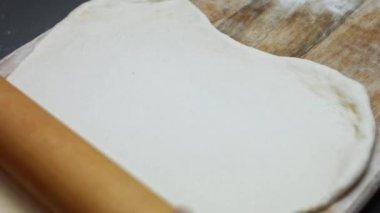 Tahta kesme tahtasının üzerinde ton balıklı pizza için taze hamur hazırlıyorum. Sevgililer Günü için kalp şeklinde ton balıklı pizza hazırlıyorum. 4K video