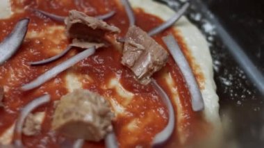 Pizza hamuruna ton balığı serpiştirmek. Sevgililer Günü için kalp şeklinde ton balıklı pizza hazırlıyorum. 4K video. Sanatsal çekim