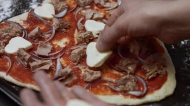 Kalp şeklinde mozarella dilimleri pizza hamurunun üzerine yayılıyor. Sevgililer Günü için kalp şeklinde ton balıklı pizza hazırlıyorum. 4K video.