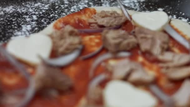 Vista de perto da massa de pizza em forma de coração com ingredientes. Preparando a pizza de atum em forma de coração para o Dia dos Namorados para um ente querido. Vídeo 4K — Vídeo de Stock