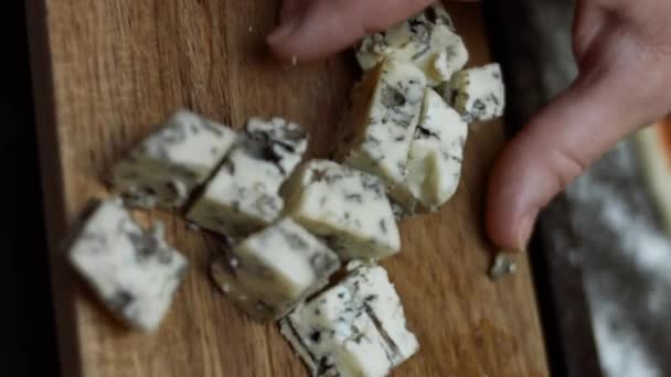 Espalhando queijo azul dinamarquês sobre massa de pizza. Preparando a pizza de atum em forma de coração para o Dia dos Namorados para um ente querido. Vídeo 4K. Tiro artístico — Vídeo de Stock