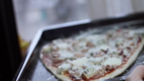 Gotowanie domowej roboty pizzy w piekarniku. Samice wkładają niegotowaną pizzę do piekarnika na patelni. Przygotowywanie pizzy z tuńczyka w kształcie serca na Walentynki dla ukochanej osoby. Wideo 4K — Wideo stockowe