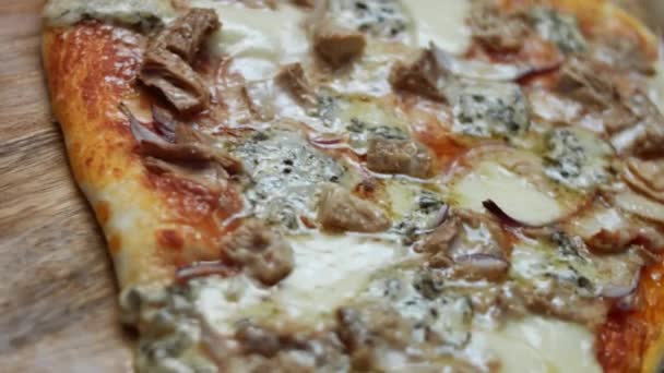 Warme zelfgemaakte pizza op een houten plank. Hartvormige tonijnpizza voor Valentijnsdag voor een geliefde als verrassingsmaaltijd. 4K video. Artistieke schietpartij — Stockvideo
