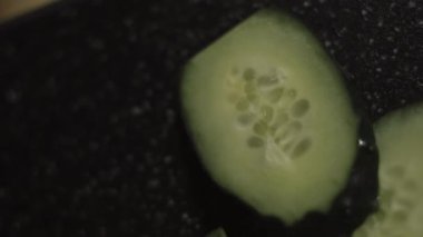 Tahta kesme tahtasında dilimlenmiş taze salatalıklar. Evde mutfakta yengeç çubuğu, peynir, salatalık, konserve mısır ve yumurta salatası hazırlıyorum. Makro