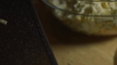 Salataya dilimlenmiş taze salatalık ekliyorum. Evde mutfakta yengeç çubuğu, peynir, salatalık, konserve mısır ve yumurta salatası hazırlıyorum. Sanatsal çekim, makro