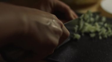 Tahta kesme tahtasıyla taze salatalıkları bıçakla dilimlemek. Evde mutfakta yengeç çubuğu, peynir, salatalık, konserve mısır ve yumurta salatası hazırlıyorum. Sanatsal çekim, makro