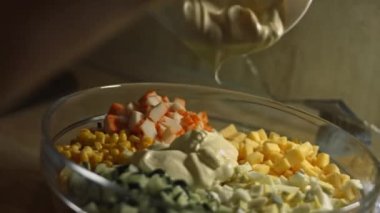 Cam kasede yengeç salatası malzemesi ve mayonez. Evde mutfakta yengeç çubuğu, peynir, salatalık, konserve mısır ve yumurta salatası hazırlıyorum. Sanatsal çekim