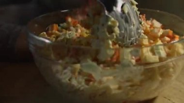 Cam kasede yengeç salatası malzemeleri, karıştırılmış malzemeler. Evde mutfakta yengeç çubuğu, peynir, salatalık, konserve mısır ve yumurta salatası hazırlıyorum. Zaman Uygulaması