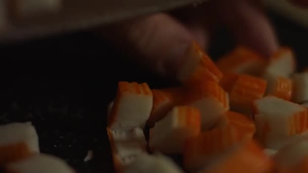 切碎的螃蟹把沙拉放在切菜板上.在家里厨房里准备螃蟹、奶酪、黄瓜、罐装玉米和鸡蛋沙拉. — 图库视频影像