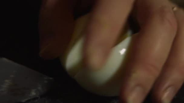 Slicing hard boiled eggs. Preparing salad of crab sticks, cheese, cucumber, canned corn and eggs in the kitchen at home. Macro — Stock Video