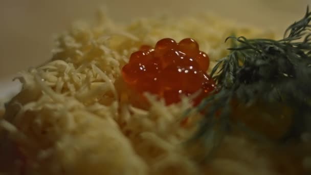 Crab salad on a plate decorated with grated cheese, dill and red salmon caviar. Artistic shooting — Stock Video