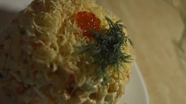 Krabí salát na talíři zdobeném strouhaným sýrem, koprem a kaviárem z červeného lososa. Umělecká střelba — Stock video