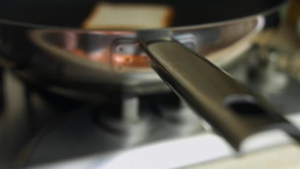 Dos rebanadas de tostadas cocidas en una sartén sobre la estufa. Cocinar deliciosos brindis en casa. Cocinar un desayuno sorpresa para marzo, 8 — Vídeo de stock