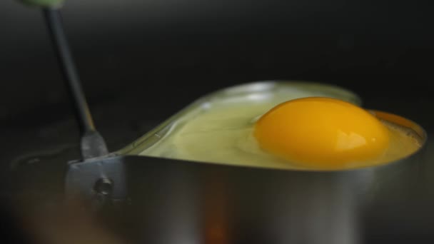 Sült tojást sütni szív alakú serpenyőben. Meglepetés reggelit főzök március 8-ra. — Stock videók