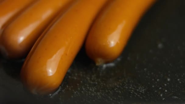 Les saucisses de viande juteuses sont frites dans une poêle à l'huile de tournesol. Cuisiner un petit déjeuner surprise pour Mars, 8. Vue macro — Video