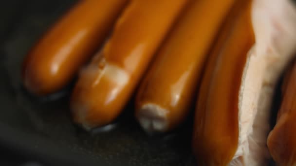 Соковиті м'ясні ковбаски смажать на сковороді в соняшниковій олії. Готуємо несподіваний сніданок на 8 березня. Перегляд макросів, сповільнення — стокове відео