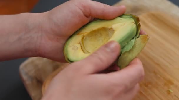 As mãos femininas retiram a casca de um abacate. Cozinhar um café da manhã surpresa para março, 8 — Vídeo de Stock