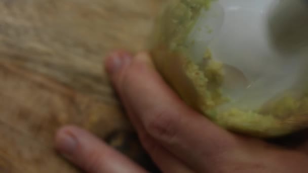 Manos femeninas mezclando trozos de aguacate en un vaso de licuadora. Cocinar un desayuno sorpresa para marzo, 8 — Vídeo de stock