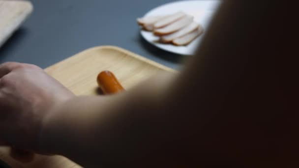 Corte de salsichas de carne suculentas em uma placa de corte de madeira. Cozinhar um pequeno-almoço surpresa para 8 de Março. Tiro artístico — Vídeo de Stock
