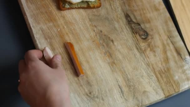 ジューシーな肉ソーセージスライスで3月という言葉を形成.アボカドとパルミジャーノチーズを砕いたトーストにハート型の卵を添えます。3月の驚きの朝食を調理します。タイムラプス — ストック動画