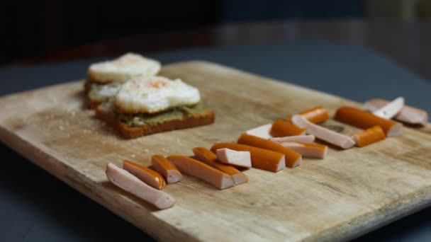 Word March utworzony z soczystych plasterków mięsa kiełbasy. Podawany z jajkami w kształcie serca na tostach z rozwalonym awokado i serem parmigiano. Przygotowuję śniadanie niespodziankę na marzec, 8. Spowolnienie — Wideo stockowe