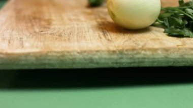 Kadın şef, ahşap kesme tahtasındaki acı yeşil biberi ikiye bölüyor. Salsa yapma süreci