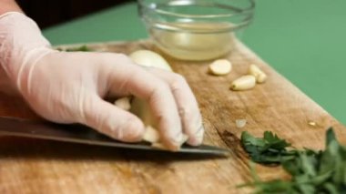 Kadın şef, tahtanın üzerinde soğan dilimlerini yana kaydırıyor. Salsa yapma süreci