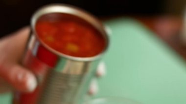 Açık bir konserve kutusundan doğranmış domatesleri el blender bardağına döküyorum. Salsa yapma süreci