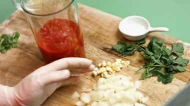 Doğranmış domateslere doğranmış soğan eklemek el blender bardağına. Salsa yapma süreci