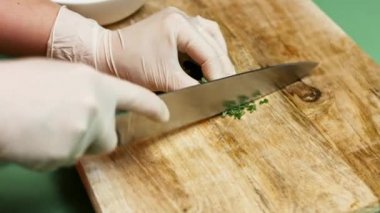 Şefin elleri kesme tahtasının üzerinde maydanoz doğruyor. Salsa yapma süreci