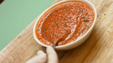 Bir kasede taze yapılmış iştah açıcı salsa sosu karıştırıyorum. Salsa yapma süreci