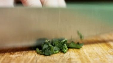 Şefin elleri ahşap tahtada taze kişniş doğruyor. Quesadilla yapma süreci. Zaman Uygulaması