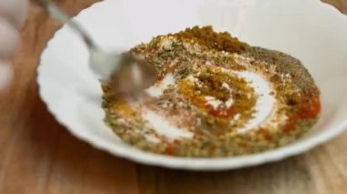 Beyaz bir kasede farklı baharatlar karıştırmak. quesadillas yapma süreci