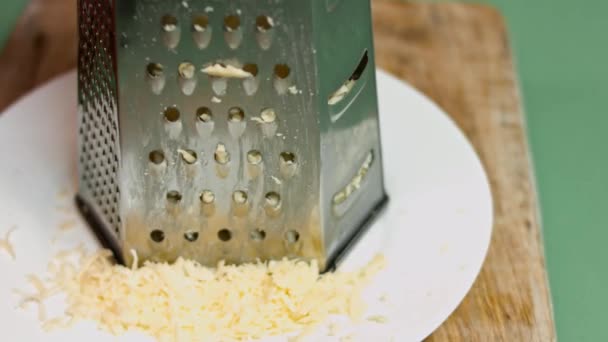 Большая куча тертого сыра на белой тарелке. Успех создания квесадилл — стоковое видео