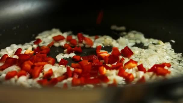 Добавление нарезанный свежий красный перец колокольчика на лук и чеснок поджаривается на сковороде. Успех создания квесадилл — стоковое видео
