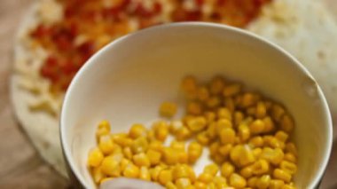 Rendelenmiş peynir ve sebzelerle dolu tortilla için konserve mısır ekliyorum. Meksika usulü tavuk eti, peynir ve sebzeli quesadilla yapma süreci. Üst görünüm