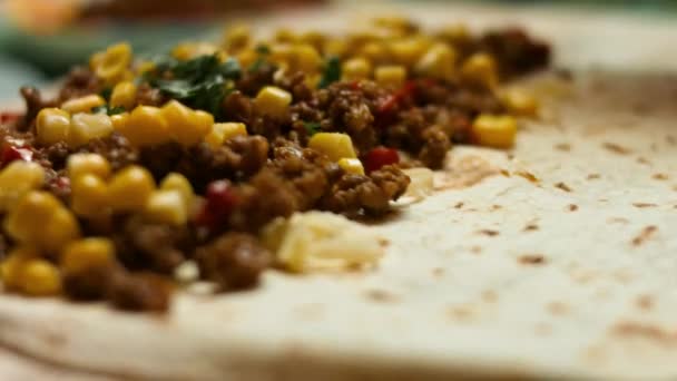 Lägga hackad koriander till mjöl tortilla fylld med riven ost, marken nötkött och grönsaker. Process för att göra mexikanska quesadillas med nötkött kött, ost och grönsaker. Makro — Stockvideo