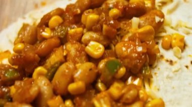 rendelenmiş peynir ve sebze 2 ile doldurulmuş un tortilla için doğranmış taze kişniş ekliyorum. Peynirli ve sebzeli Meksika dürümü yapma süreci. Makro görünüm